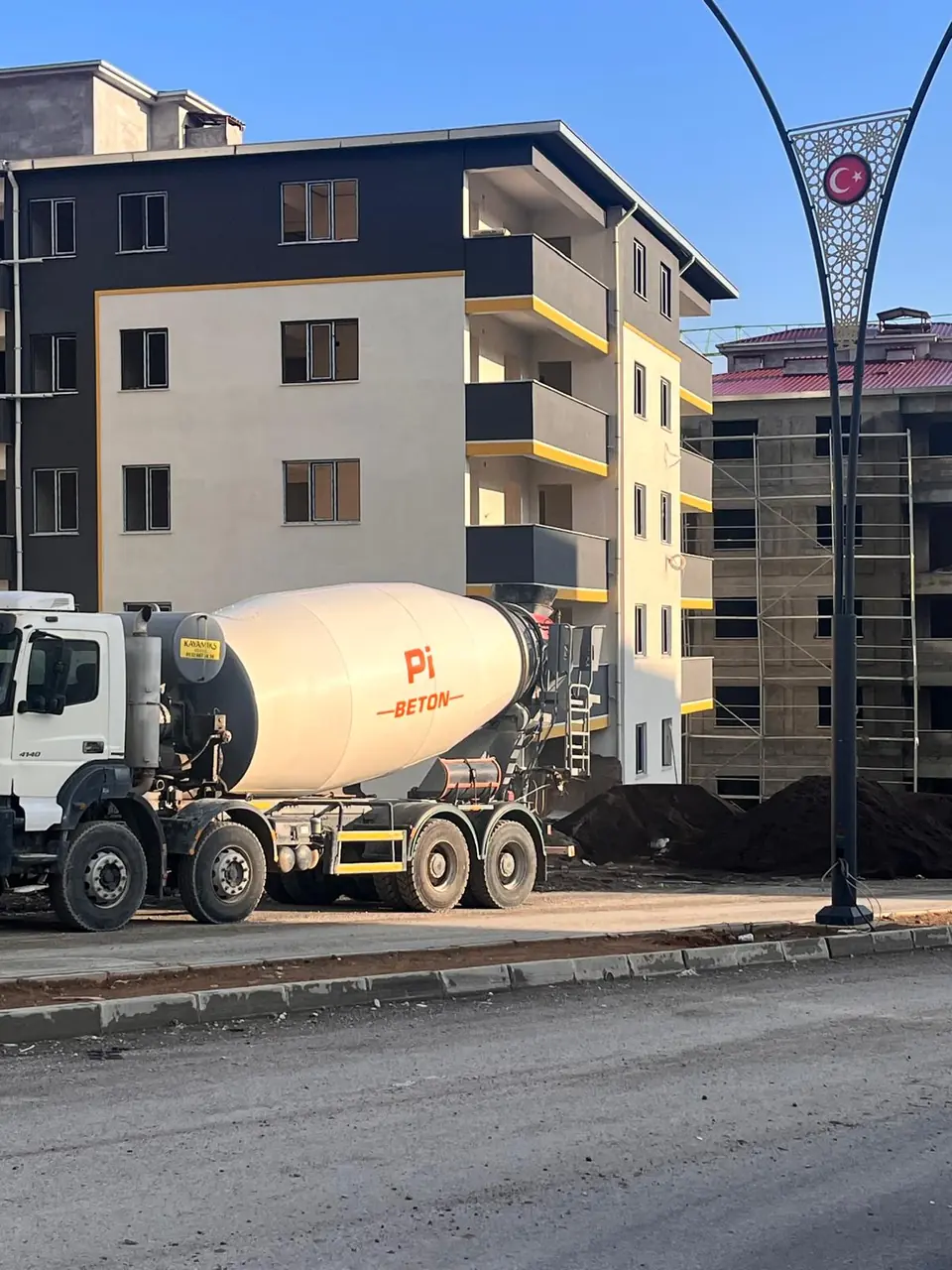 Şantiye önünde beton mikseri ve tamamlanan bloklar